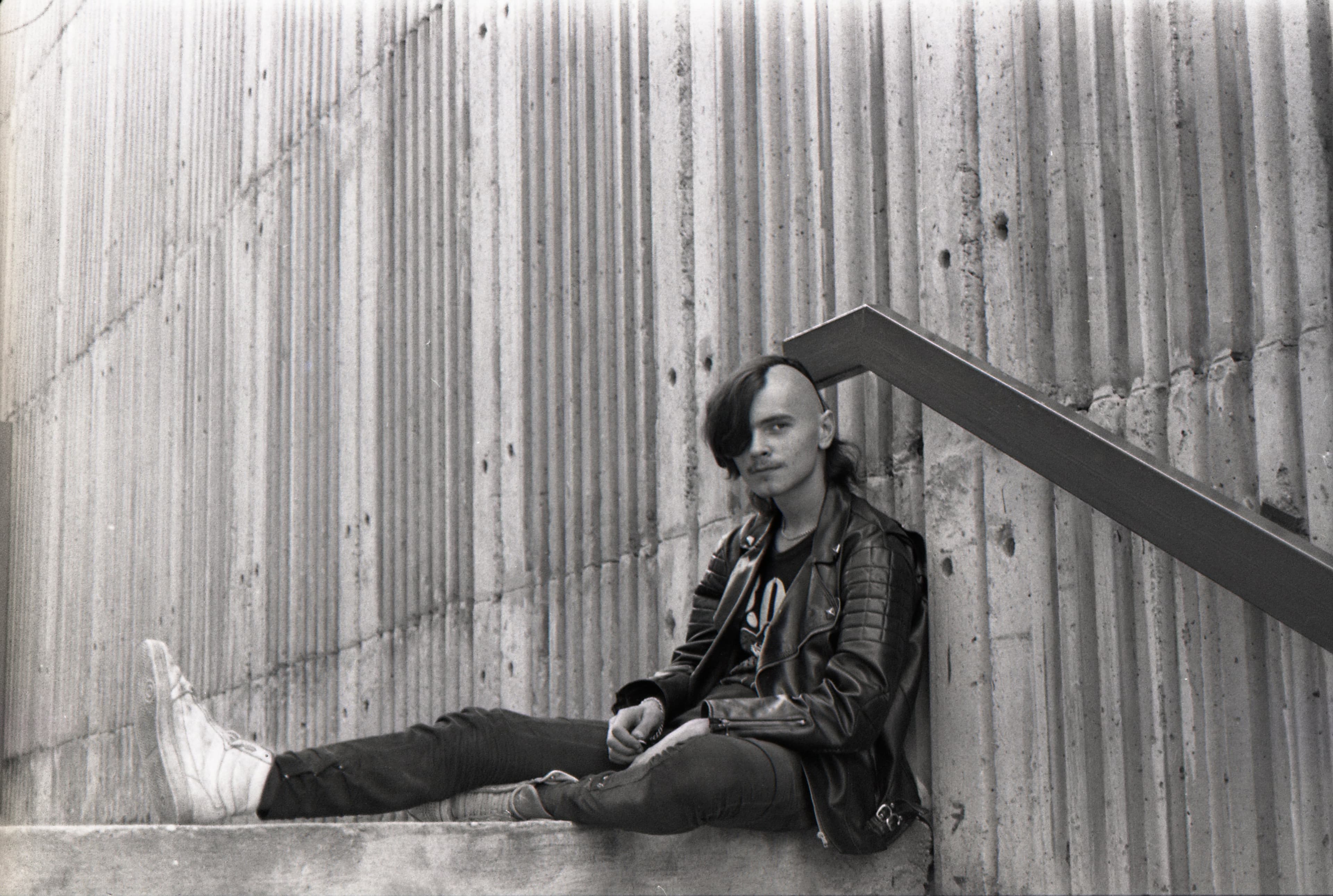 View of a black-and-white photograph of a punk rocker sitting on steps in Bratislava in 1990