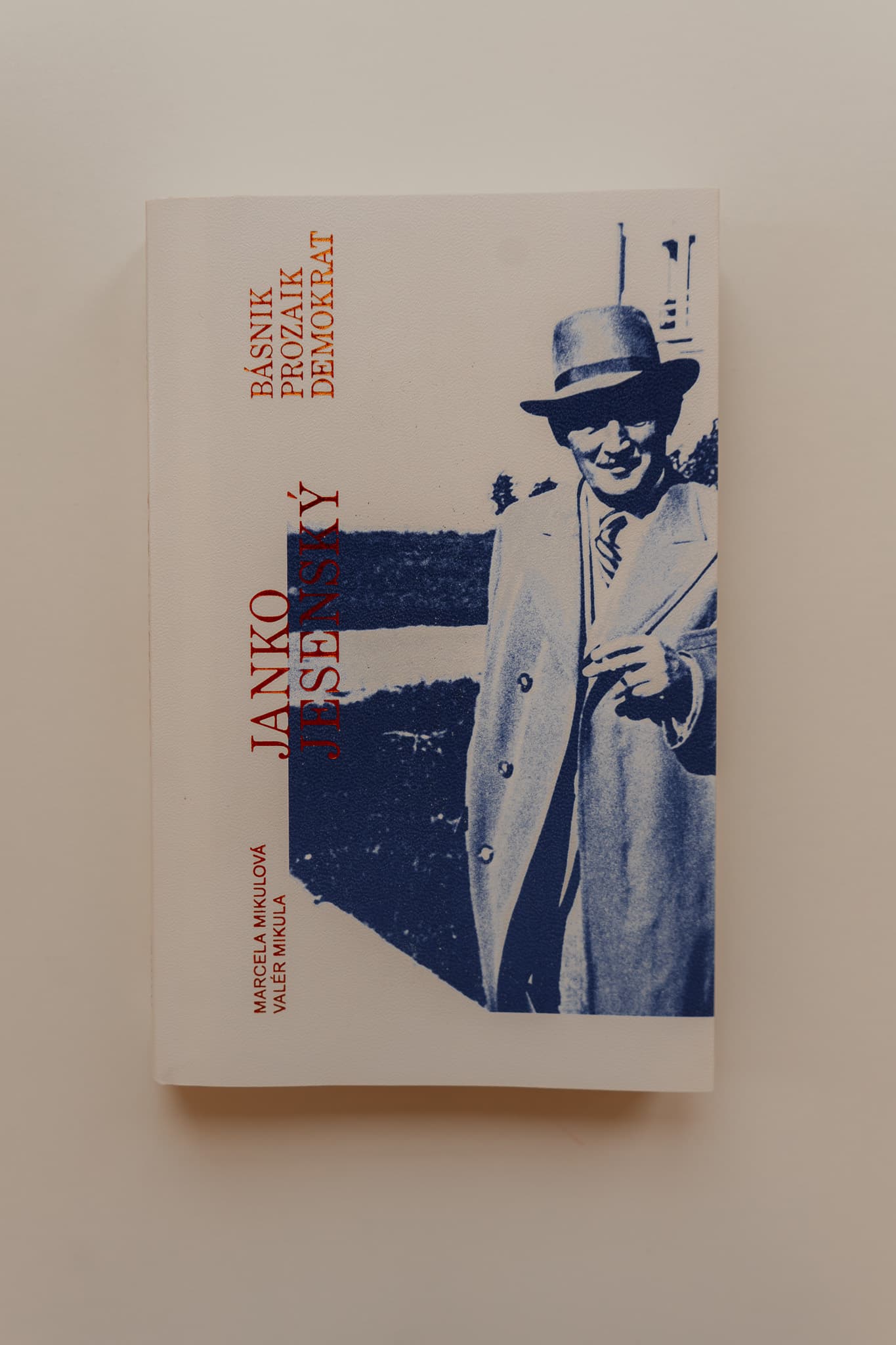 Blue photograph of Janko Jesenský wearing a hat on the book cover. The title “Janko Jesenský. Poet, Prose Writer, Democrat.” appears horizontally in red lettering.