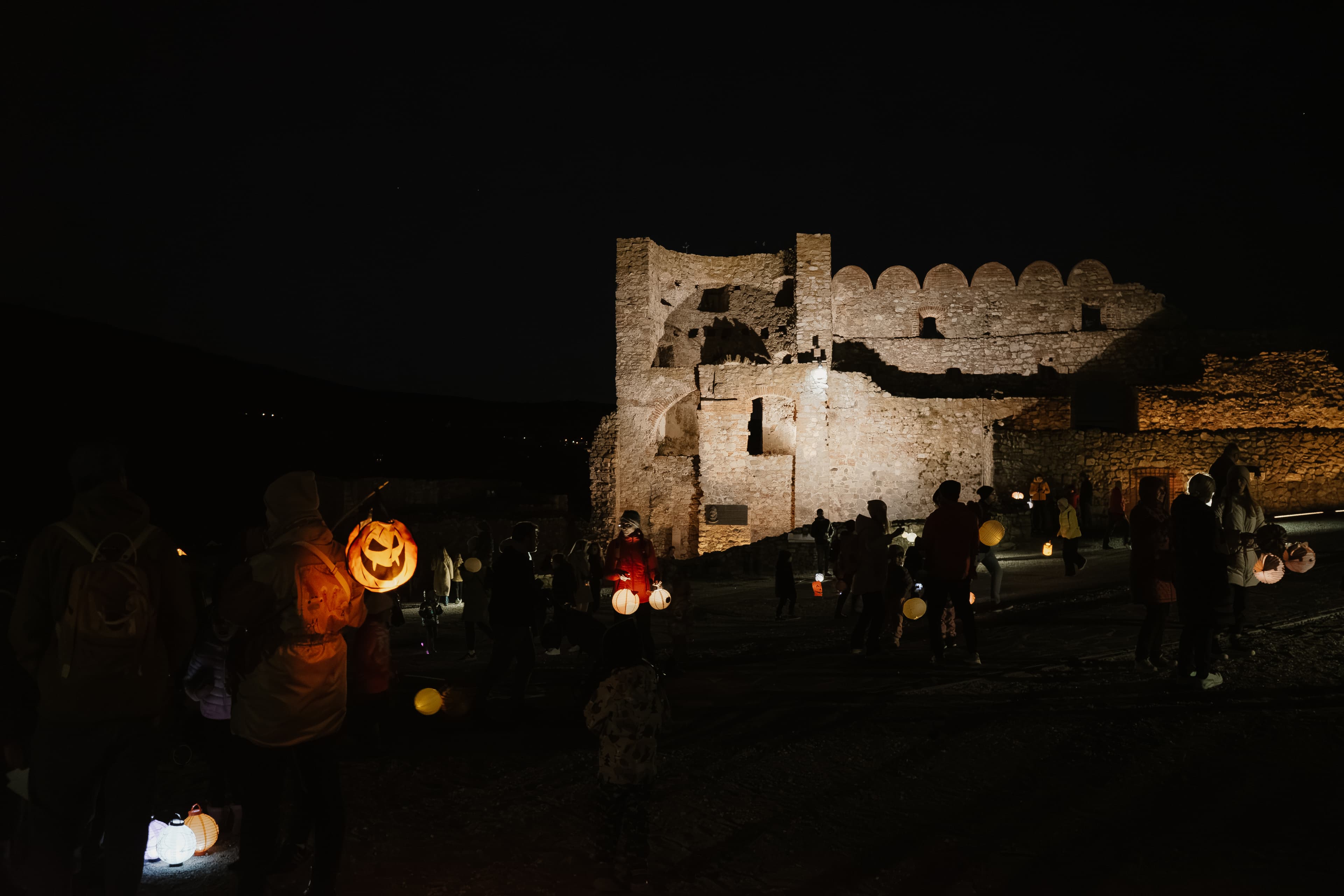 Night-time view of people during the Lantern Parade at Devín Castle